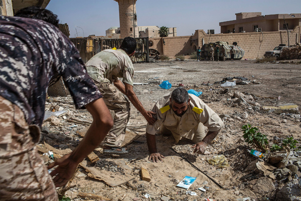 Fighters loyal to Libya’s Government of National Accord help a wounded comrade after he was shot by a Daesh sniper on the western frontline in Sirte on Sunday (AFP photo)