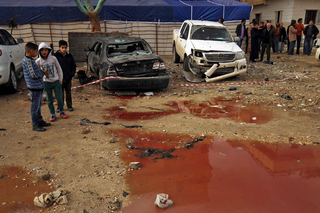 Libyans stand near a pool of blood and water as they check the aftermath of an explosion in the eastern city of Benghazi, on Wednesday (AFP photo)