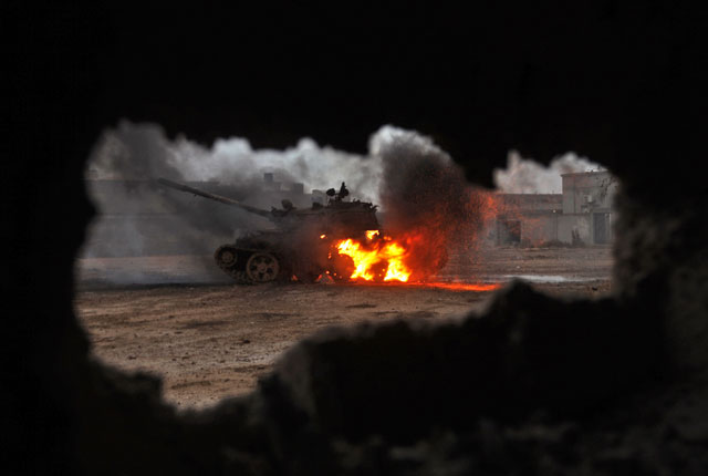A tank is seen on fire during clashes between soldiers from the Libyan national army, led by Marshal Khalifa Haftar, and extremists on Wednesday in the area of Qanfudah, south of Benghazi, Libya (AFP photo)