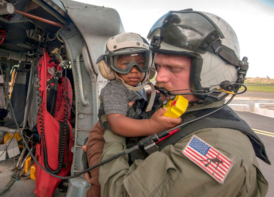 This US navy handout photo released Thursday shows Naval Aircrewman (Helicopter) 2nd Class Brandon Larnard as he carries an evacuee off an MH-60S Sea Hawk helicopter following the landfall of Hurricane Maria on the island of Dominica on Wednesday (AFP photo)