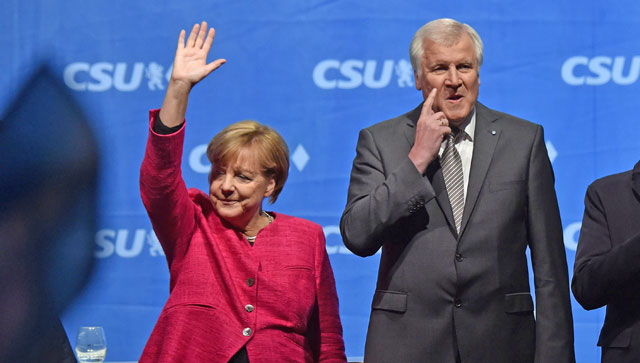 This file photo taken on September 22, shows German Chancellor Angela Merkel waving next to Bavarian State Premier and CSU Party leader Horst Seehofer (right) during an election campaign rally in Munich, southern Germany (AFP photo)