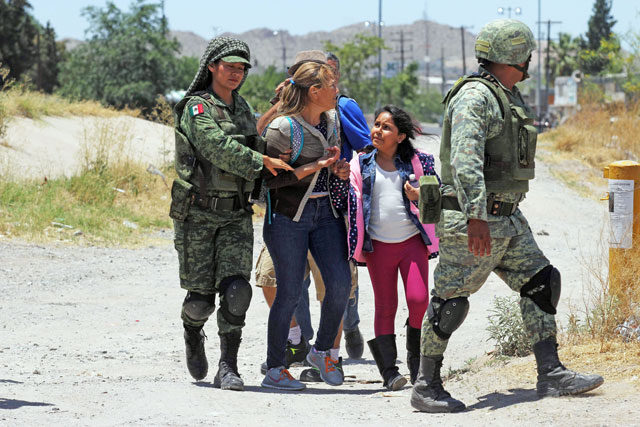 Members of Mexican national guard detain central American migrants trying to cross the Rio Bravo in Ciudad Juarez, State of Chihuahua, on June 21 (AFP photo)