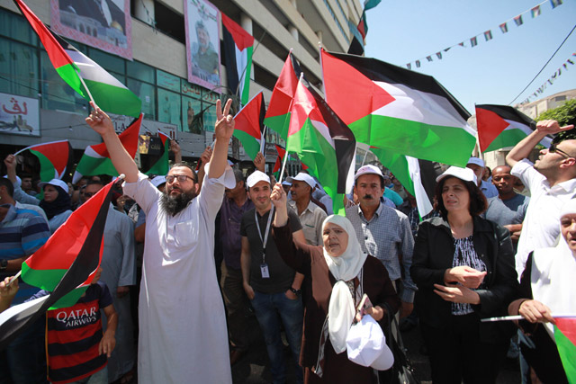 Palestinians wave Palestinian flags as they gather during a rally to support Al Aqsa Mosque after the removal of Israeli measures at the entrances to Al Aqsa Mosque  in the West Bank city of Nablus on Tuesday (Anadolu Agency photo)
