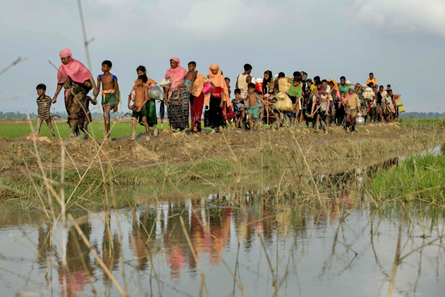 Displaced Rohingya refugees from Rakhine state in Myanmar carry their belongings as they flee violence, near Ukhia, near the border between Bangladesh and Myanmar, on Monday (AFP photo)