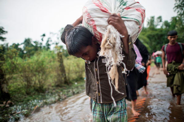 A young Rohingya Muslim refugee walks towards refugee camps after crossing the border from Myanmar at the Bangladeshi shores of the Naf River in Teknaf, on Thursday (AFP photo)