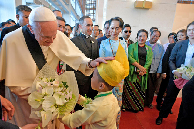 Pope Francis blesses a child as he arrives with Myanmar's State Counsellor Aung San Suu Kyi to attend a meeting with members of the civil society and diplomatic corps in Naypyitaw, Myanmar, on Tuesday (Reuters photo)