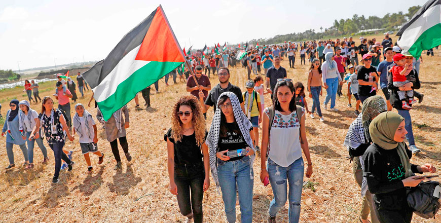 Palestinian and Arab Israeli protesters wave Palestinian flags as they march for the right of return for Palestinian refugees who fled their homes or were expelled during the 1948 war that followed the creation of the state of Israel, on Thursday (AFP photo)