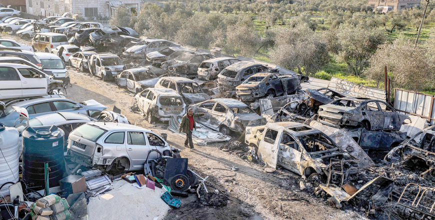 A man walks past destroyed cars at a scrapyard in the town of Huwara near Nablus in the occupied West Bank on Monday, after they were torched overnight (AFP photo)