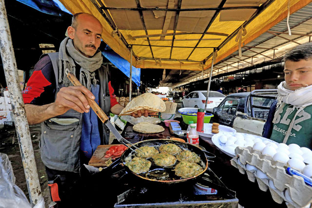 A Syrian man sells food at a street market in the northern Syrian Kurdish enclave of Afrin on Monday (AFP photo)