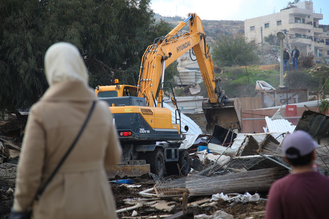 An excavator demolishes a building after Israeli forces' wide-scaled operations in Isawiya district of East Jerusalem on Tuesday (Anadolu Agency photo)