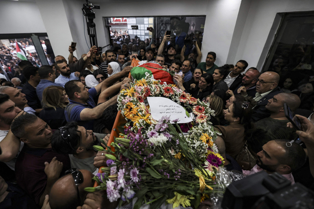 Colleagues surround the corpse of veteran Al Jazeera journalist Shireen Abu Akleh as it is brought to the offices of the news channel in the West Bank city of Ramallah on Wednesday (AFP photo)