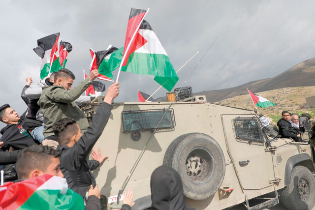 Palestinian demonstrators stand on the back of an Israeli forces jeep during a demonstration near the West Bank village of Tubas, near the Jordan Valley, on Wednesday, during a demonstration against the US President Donald Trump's peace proposals (AFP photo)