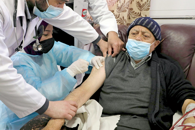 A Palestinian patient, suffering from kidney failure, receives a shot of Russia's Sputnik V coronavirus vaccine at Alia Hospital in the West Bank town of Hebron on Sunday (AFP photo)