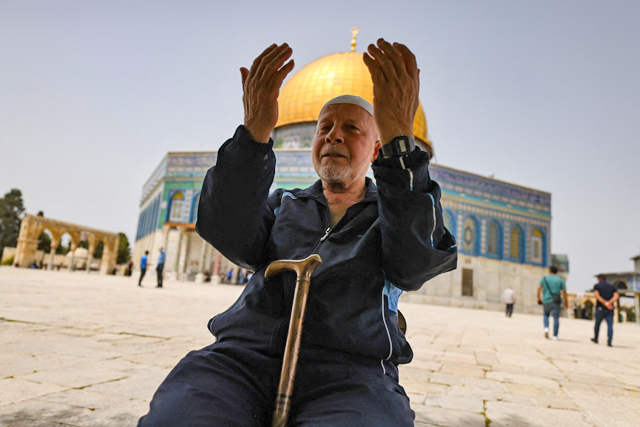 A Palestinian man prays in front of the Dome of Rock mosque at Al Aqsa Mosque compound in Jerusalem's Old City on Sunday (AFP photo)