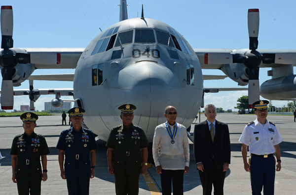 Philippine Defence Secretary Delfin Lorenzana (4th left) along with US ambassador to the Philippines Philip Goldberg (3rd right) pose for photos with Filipino military officials during the hand-over ceremony at a military base in Manila on Monday (AFP photo)