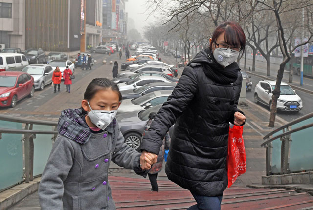A mother and daughter climb a pedestrian overpass on a heavily polluted day in Shijiazhuang, in northern China's Hebei province, on Wednesday (AFP photo)