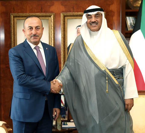 Turkish Foreign Minister Mevlut Cavusoglu (left) and Kuwait's Foreign Minister Sheikh Sabah Khalid Al Hamad Al Sabah (right) shake hands during their meeting in Kuwait City on Thursday (Anadolu Agency photo)