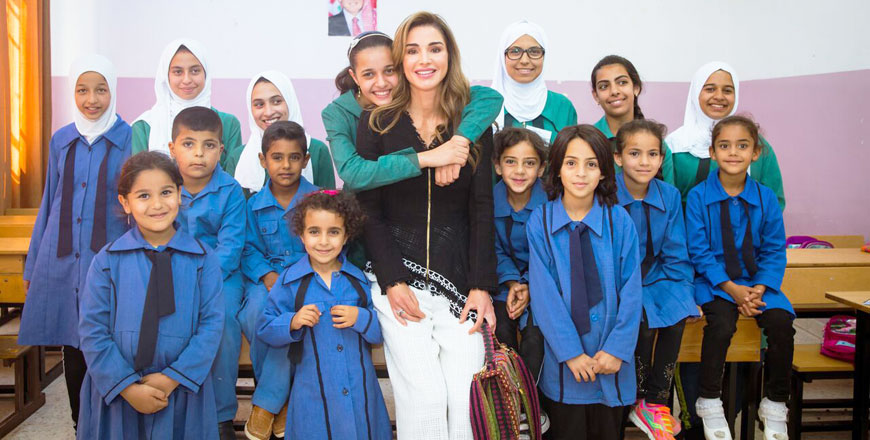 Her Majesty Queen Rania poses for a group photo at Manshiyet Husban Co-educational Secondary School in Naou on Monday (Photo courtesy of Royal Court)