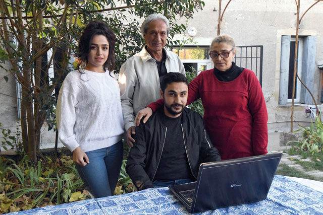 Members of the Al Fakhry family — Syrian refugees from the city of Raqqa — the daugther Reham (left), the son Haitham (centre bottom) and their parents Assad (central top) and Shiar, pose in Quissac on October 30 (AFP photo)