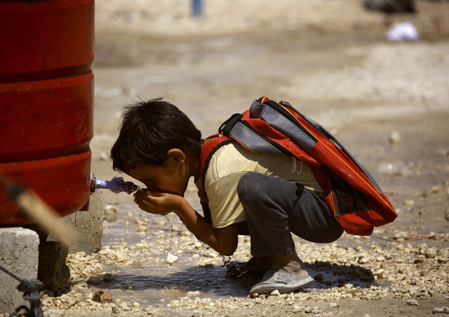 A displaced child from the Daesh group’s Syrian stronghold of Raqqa, drinks water as he heads to attend the first day of the new school year at a camp for internally displaced people in Ain Issa on Tuesday (AFP photo)