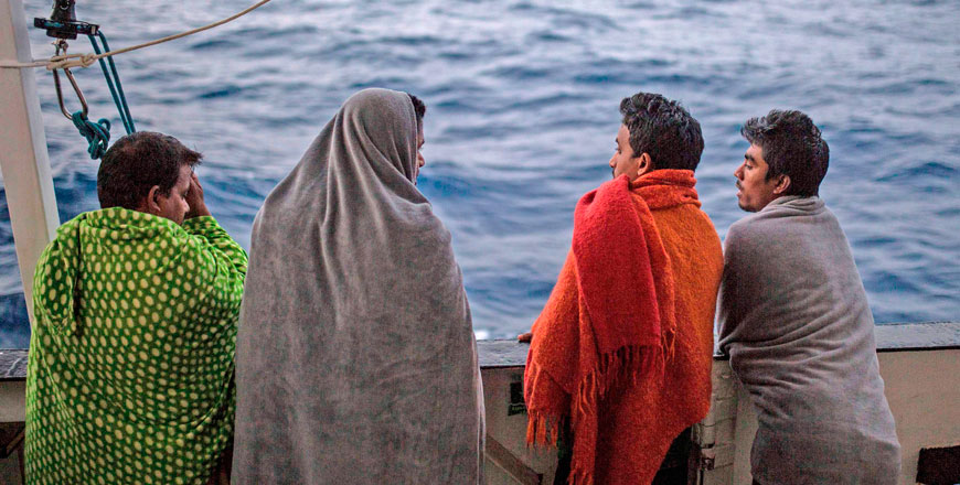 Migrants look at the sea from the deck of the boat of the NGO Proactiva Open Arms on Sunday. A Spanish NGO said on June 30 it had rescued 59 migrants as they tried to cross the Mediterranean from Libya and would dock in Barcelona in Spain after Italy and Malta refused access (AFP photo)