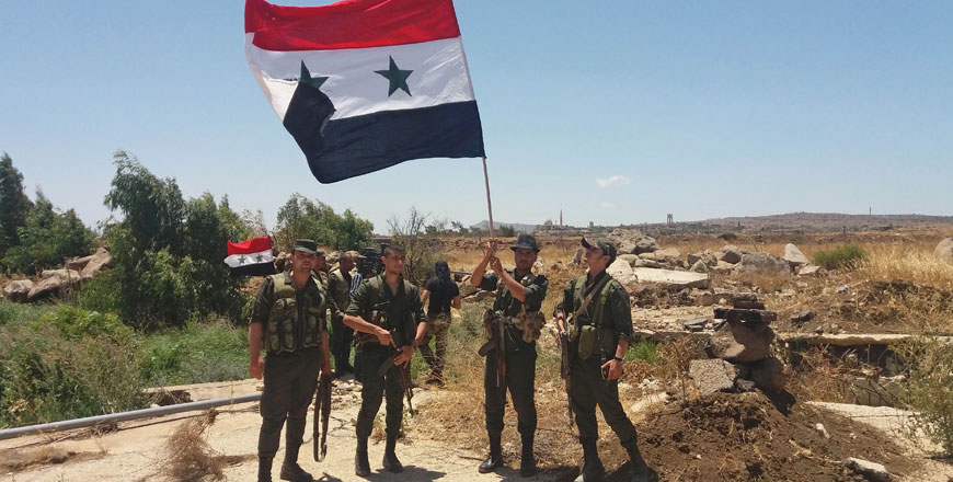 This handout photo released by the official Syrian Arab News Agency on Thursday shows Syrian army soldiers carrying the national flag in the village of Hamidiya in the southern province of Quneitra on the frontier with the Israeli-occupied Golan Heights, around four years after losing control of the area  (AFP photo)