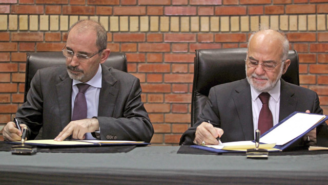 Foreign Minister Ayman Safadi (left) signs an agreement with his Iraqi peer, Ibrahim Al Jaafari, in Baghdad on Thursday  (Petra photo)