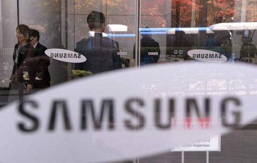 Employees walk past logos of Samsung Group at its headquarters in Seoul, South Korea, Wednesday (AP photo)