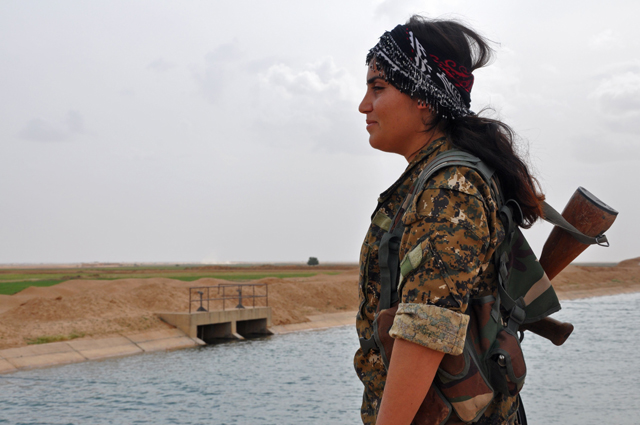 A female fighter from the Syrian Democratic Forces, which consists of an alliance of Kurdish and Arab fighters, stands near Tishreen Farms, some 17 kilometres north of Raqqa, on Tuesday (AFP photo) 