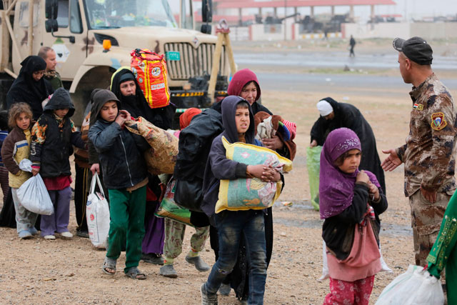 Iraqi civilians, fled from clashes between Iraqi Army and Daesh terrorists, wait to be sent to refugee camp in Hamam Al Alil town, as the operation to retake Iraq’s Mosul from Daesh terrorists continues in Mosul, Iraq, on Thursday (Anadolu Agency photo)