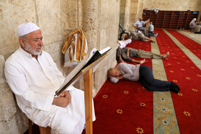 A Muslim man prays as others rest on the floor during the Muslim holy month of Ramadan, on the compound known to Muslims as Noble Sanctuary and to Jews as Temple Mount, in Jerusalem's Old City, on Wednesday (Reuters photo)