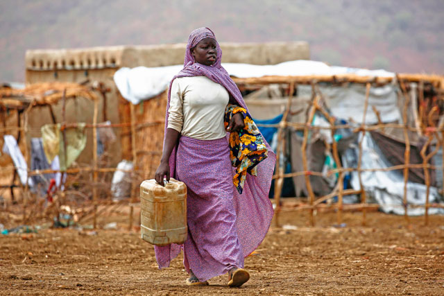 A displaced woman carries a container to collect water at a camp for Internally Displaced Persons near Kadugli, the capital of Sudan's South Kordofan state, during a United Nations humanitarian visit, on May 13 (AFP photo)