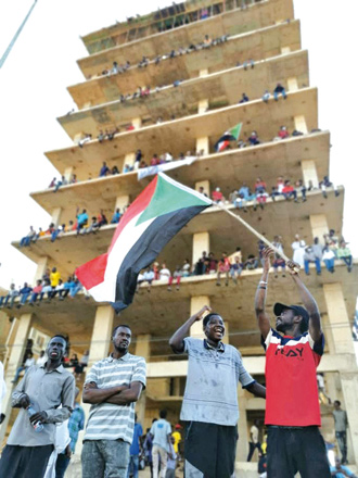Sudanese anti-coup protesters wave the national flag as they gather in a street in the capital Khartoum on Saturday, to express their support for the country's democratic transition which a military takeover and deadly crackdown derailed (AFP photo)