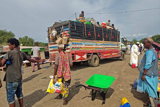People wait to board a bus from Sudan's Qalabat border crossing with Ethiopia on July 31. Sudan's paramilitaries have ordered civilians to vacate homes in the capital's south, several residents said, as fighting between the forces of rival generals raged in the western Darfur region (AFP photo)