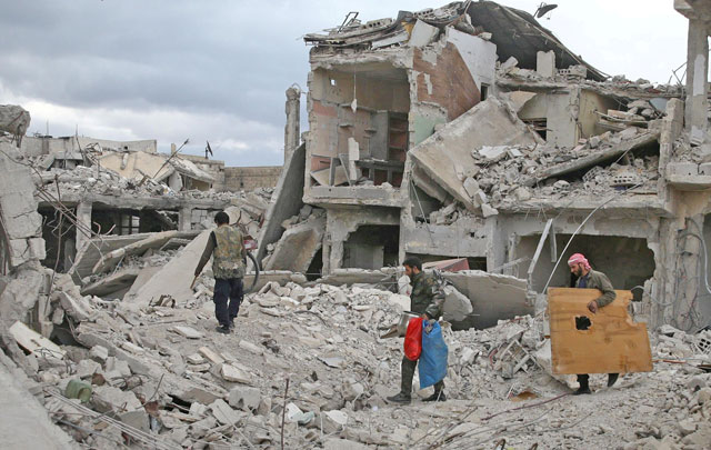 People walk on the rubble of damaged buildings in the besieged town of Douma, Eastern Ghouta, in Damascus, Syria, on March 30 (Reuters file photo)