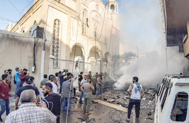People extinguish a fire at the scene of a car bomb explosion outside a church in the Kurdish-majority city of Qamishli in northeast Syria on Thursday (AFP photo)