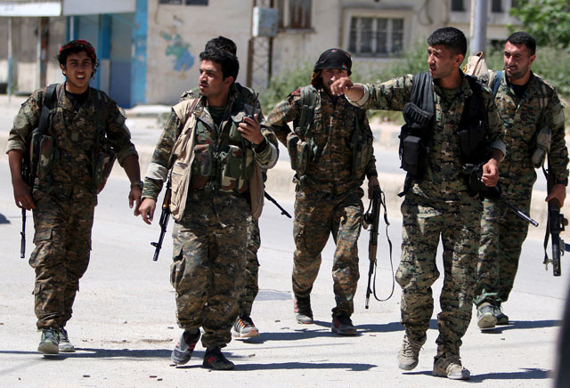 Kurdish fighters from the People’s Protection Units walk along a street in the southeast of Qamishli city, Syria, April 22, 2016 (Reuters photo)