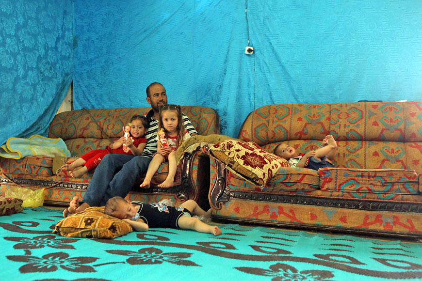 A Syrian refugee from Aleppo sits with his children in a makeshift tent in a Syrian refugee camp in the town of Kab Elias in Lebanon’s Bekaa Valley on Monday (AFP photo)