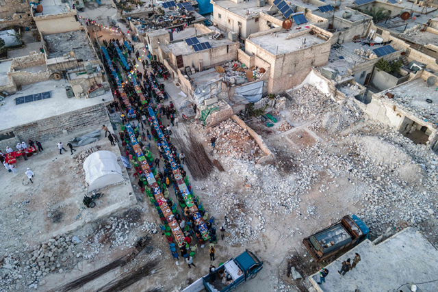 This aerial view shows locals affected by the February 6 earthquake attending a mass iftar — the fast-breaking meal at sunset — in the town of Atareb in the rebel-held western countryside of Aleppo province on March 31 at the end of the fasting day during the holy month of Ramadan (AFP photo)