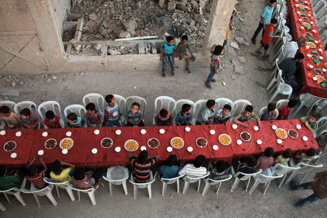 Syrian residents of the rebel-held town of Douma, on the outskirts of the capital Damascus, break their fast with the ‘iftar’ meal on a heavily damaged street on Sunday, during the holy month of Ramadan (AFP photo)