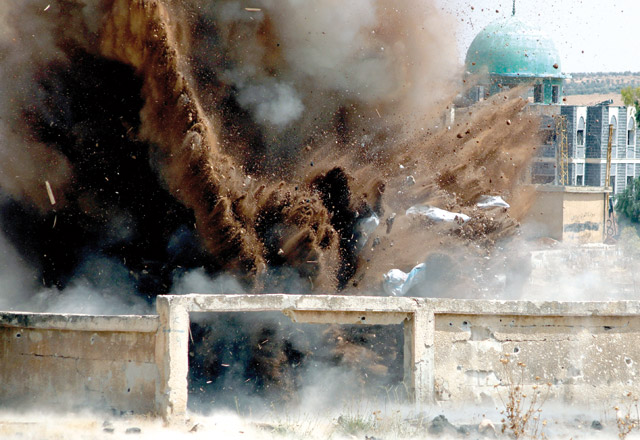 Civil defence members safely detonate cluster bombs in the rebel-held area in Daraa, Syria, on Wednesday (Reuters photo)