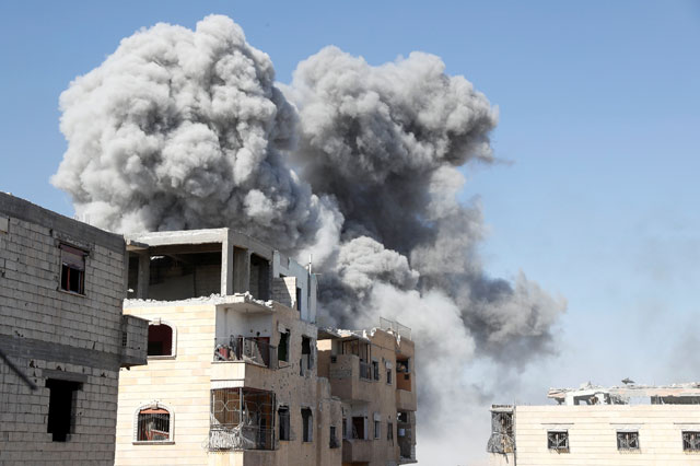 Smoke rises at the positions the Daesh militants after an air strike by the coalition forces near the stadium in Raqqa, Syria (AFP photo)