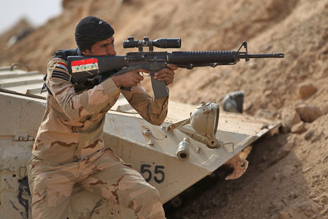 An Iraqi forces member holds a position on Saturday near the Syrian border after recapturing the border town of Al Qaim, west of Anbar, from Daesh group extremists a day earlier (AFP photo)