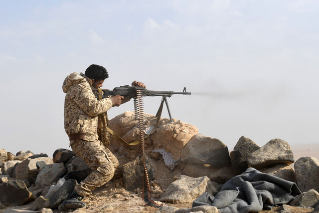 A member of the Syrian regime forces fires towards rebel positions near the village of Sawwan, south of Khanasser, in Aleppo Governorate on Sunday, as they prepare to advance towards rebel-held positions west of Aleppo near Abu Al Zuhur military airport in the Idlib province countryside (AFP photo)