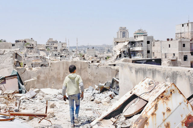 This file photo taken on July 22, 2017, shows a Syrian boy walking amid the rubble of destroyed buildings in the northern city of Aleppo, which was recaptured by government forces in December 2016. Syria's six-year war has claimed more than 340,000 lives, forced millions to flee their homes and left Syria in ruins (AFP photo)