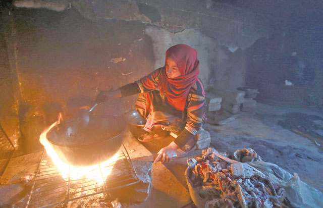 A Syrian woman cooks inside a school turned into a shelter for people displaced by the war, in the rebel-controlled town of Hamouria, in the eastern Ghouta region on the outskirts of the capital Damascus, on December 23 (AFP photo)