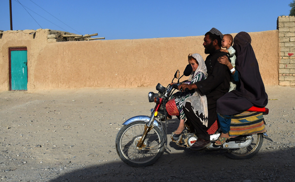 In this photo taken on October 4, an Afghan family travels on a motorbike in Lashkar Gah, the capital city of Helmand province (AFP photo)