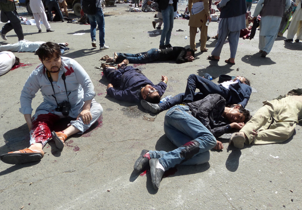 Wounded man sits next to other victims of a blast during a demonstration in Kabul, Afghanistan, on Saturday (Reuters photo)