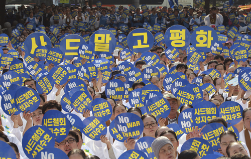 South Korean Won Buddhism monks hold up cards during a rally to oppose a plan to deploy an advanced US missile defence system called Terminal High-Altitude Area Defence, or THAAD, in Seoul, South Korea, Tuesday (AP photo)
