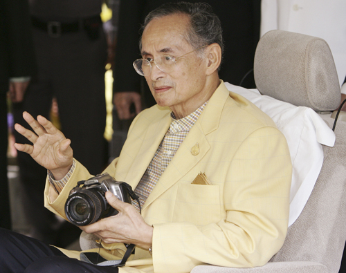 In this August 4, 2006 file photo,Thailand's King Bhumibol Adulyadej holds a camera as he waves while leaving Siriraj Hospital in Bangkok (AP photo)